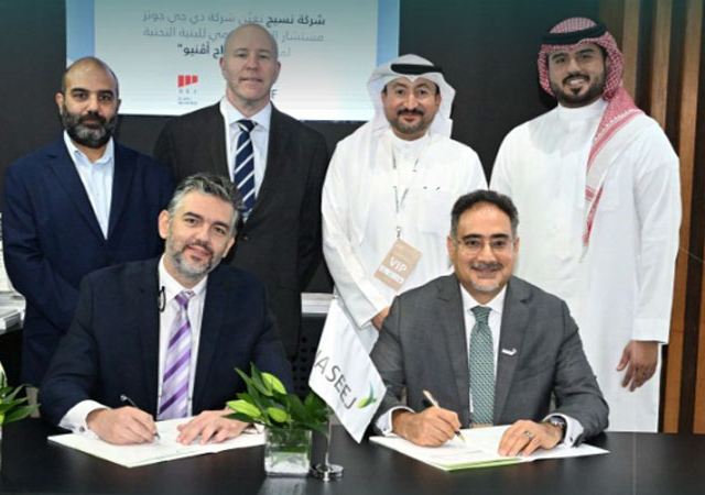Bou Joudeh and Al Arrayed (right) signing the deal, watched by senior officials.